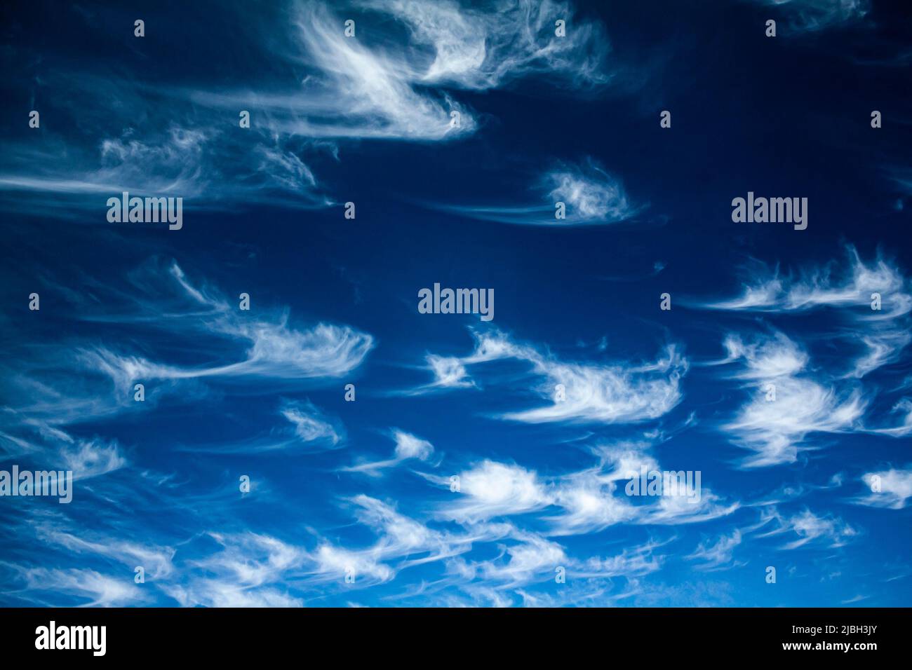 Wispy cirrus clouds on a blue sky Stock Photo