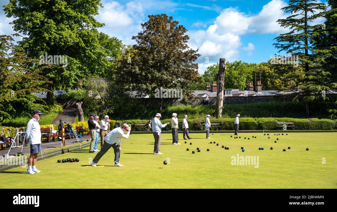 Elderly men play lawn bowls on a bowling green in Chichester, West Sussex, UK. Stock Photo