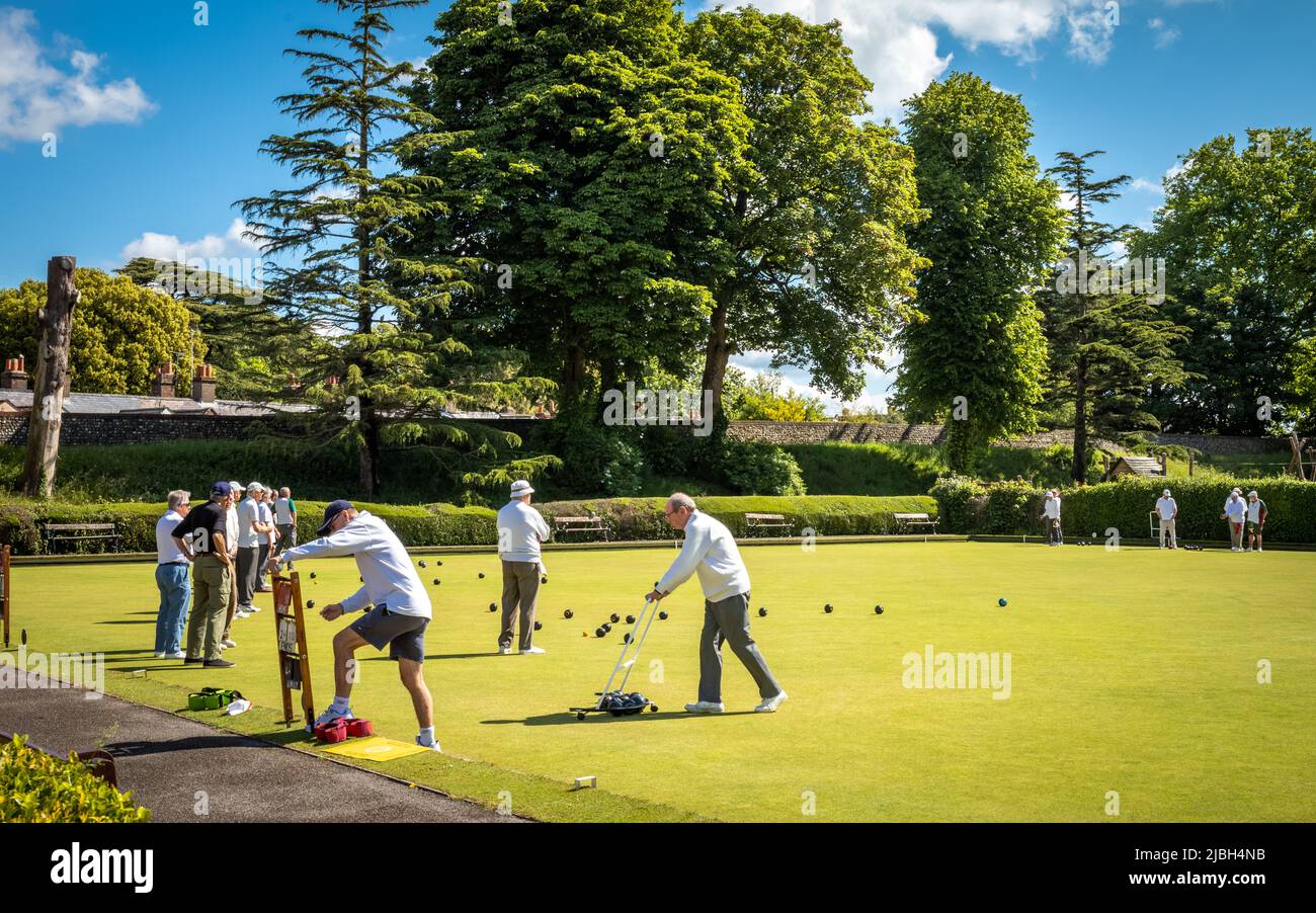 Elderly men play lawn bowls on a bowling green in Chichester, West Sussex, UK. Stock Photo