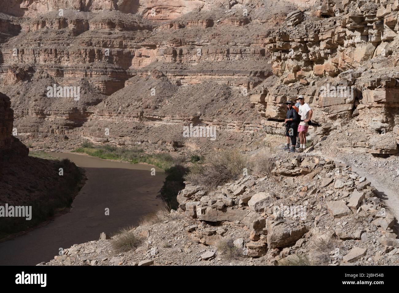 River explorers and tourists climb the steep walls along the San Juan River canyon in southwest Utah. Stock Photo