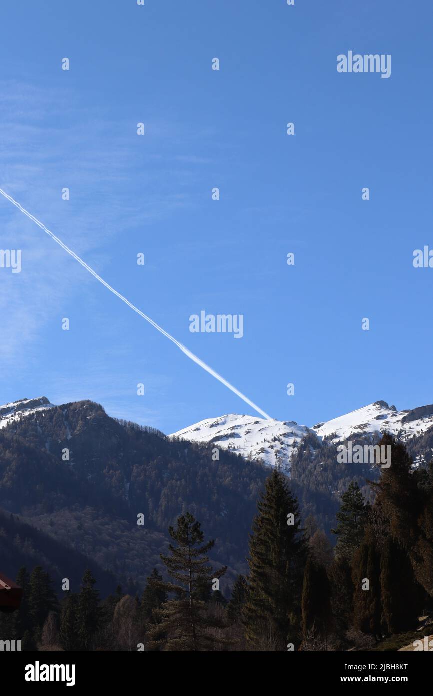 The trace of a plane passing over the mountain creating the impression