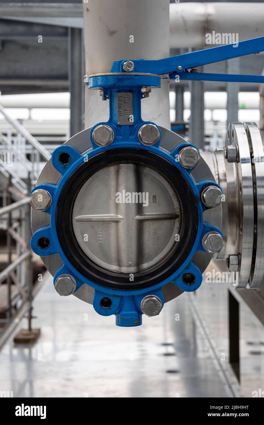 An industrial open butterfly valve in a stainless steel pipe system, suitable for the transport of liquids or gases Stock Photo