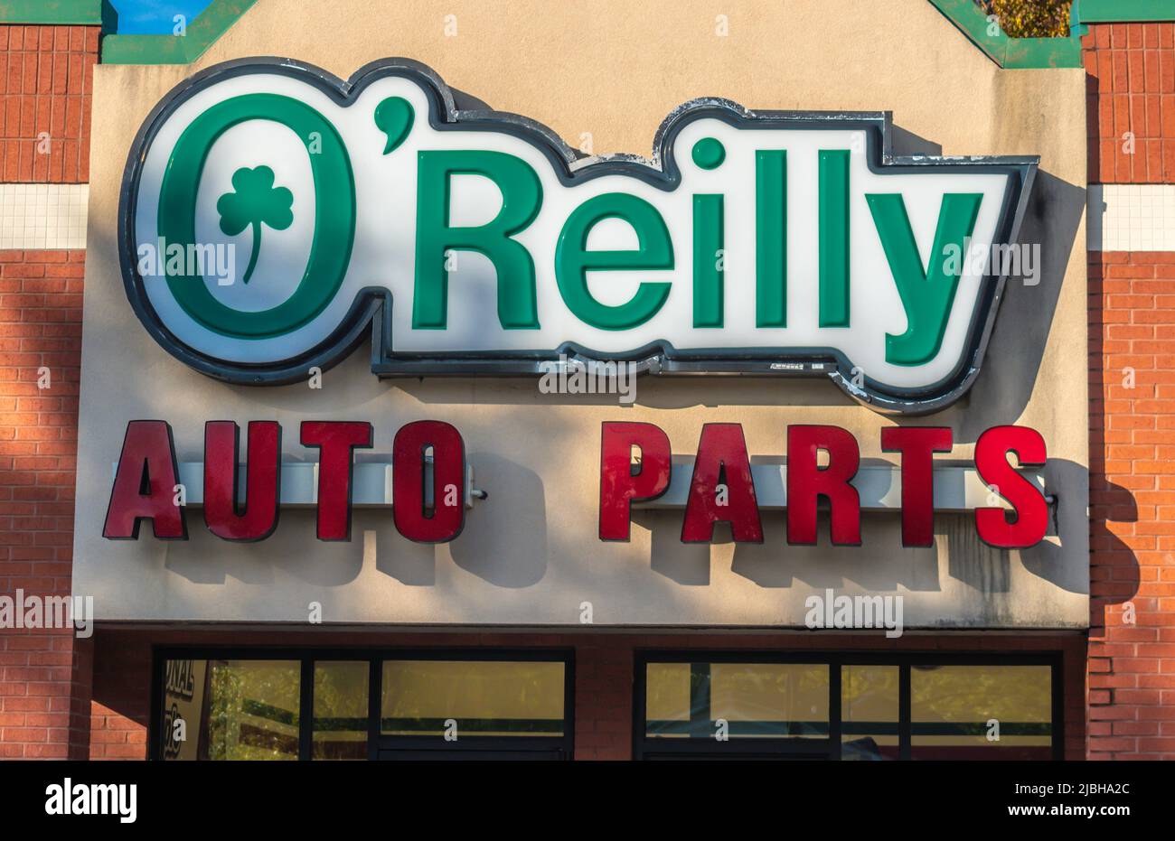 O'Reilly Auto Parts store's exterior facade brand and logo signage in the soft light of sunset with sunlight and shadows in Salisbury, North Carolina. Stock Photo