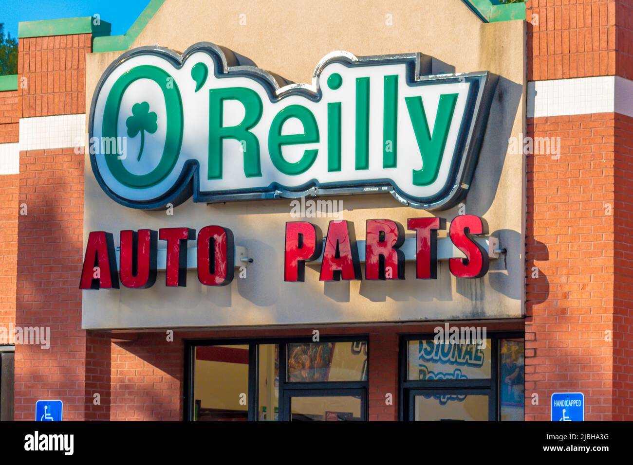 O'Reilly Auto Parts store's exterior facade brand and logo signage in the soft light of sunset with sunlight and shadows in Salisbury, North Carolina. Stock Photo