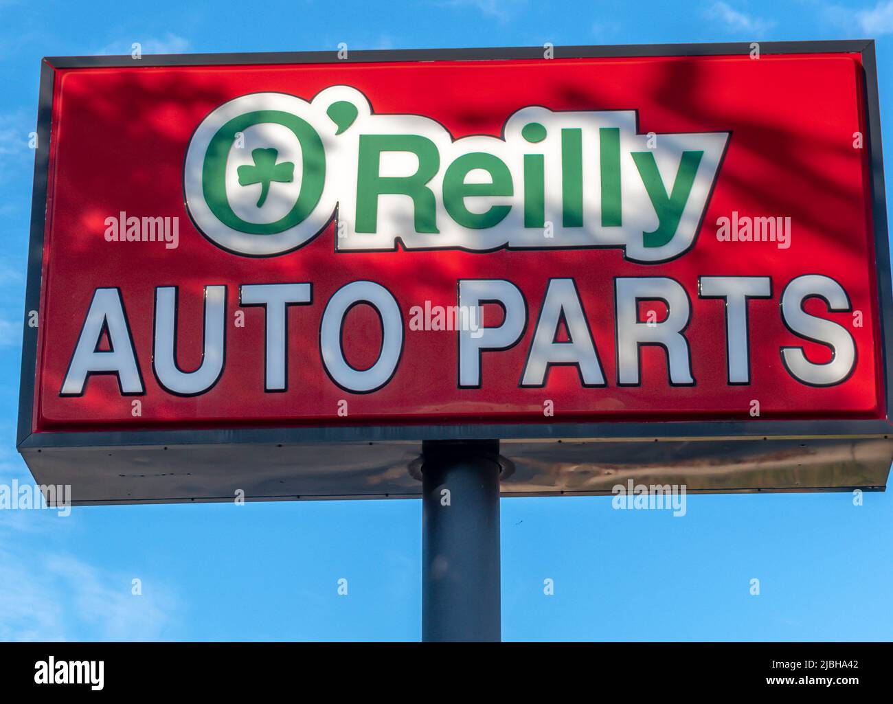 O'Reilly Auto Parts store's outdoor, free standing brand and logo street advertising in sunset light with shadows in Salisbury, North Carolina. Stock Photo