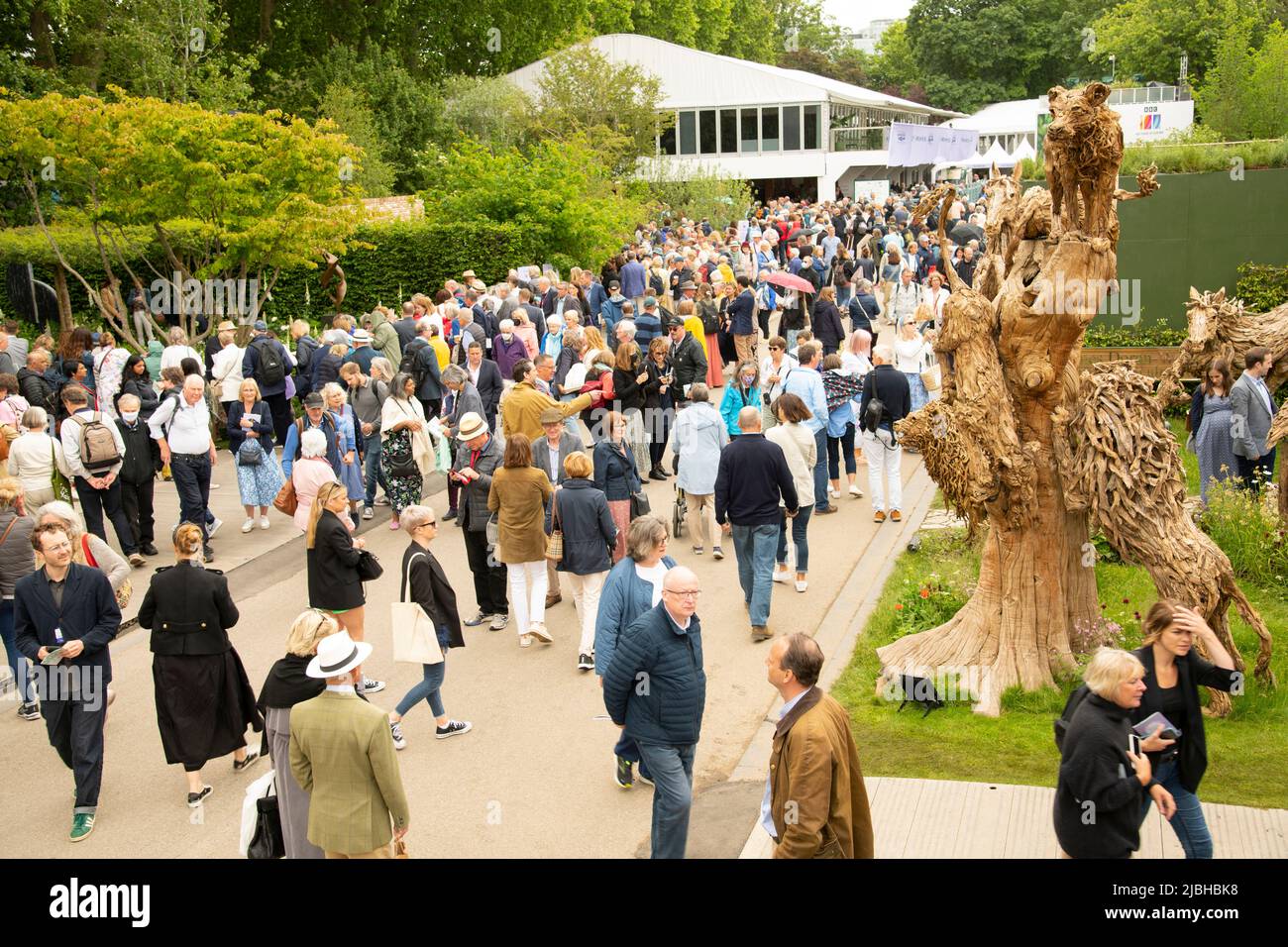 A large wood sculpture surrounded by visitors in an aerial view of the grounds of the Chelsea Flower Show Stock Photo