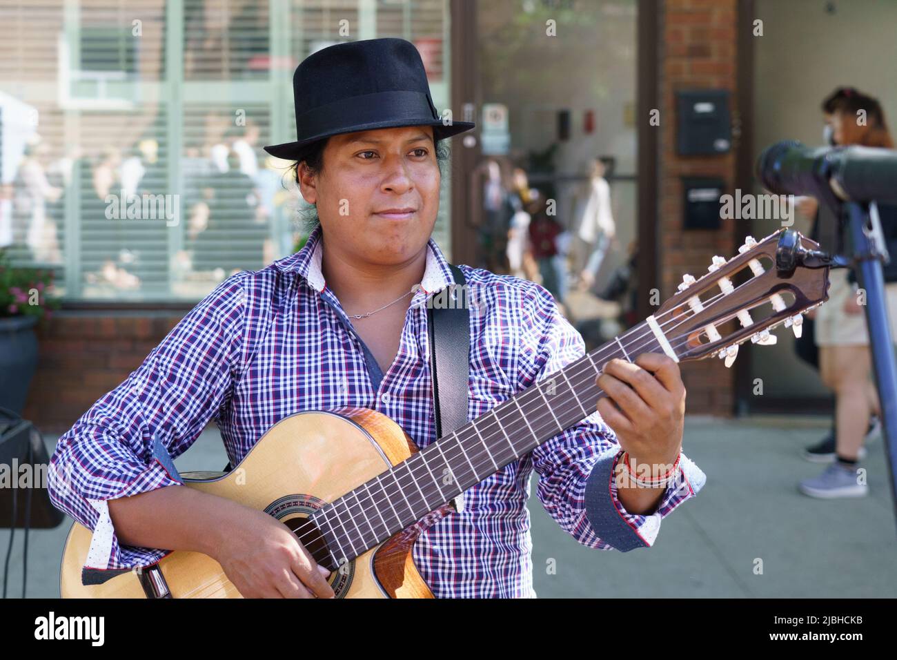 A man of Latin American ethnicity plays the guitar during the Do West Festival. Stock Photo