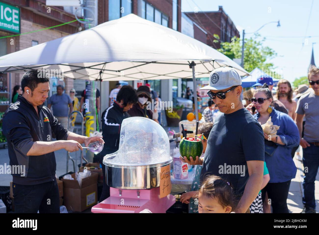A Man Is Buying Cotton Candy During The Do West Festival Stock Photo