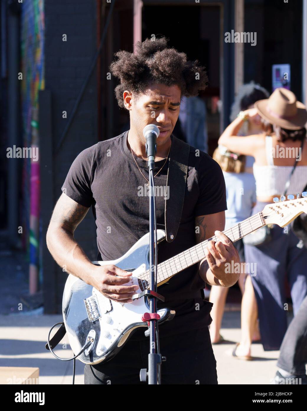 Artist named Free The Revolution sings and plays guitar during the Do West Festival. Stock Photo