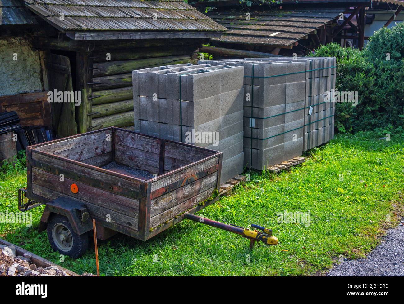 Building materials – concrete blocks and wheelbarrow in the yard of country house Stock Photo