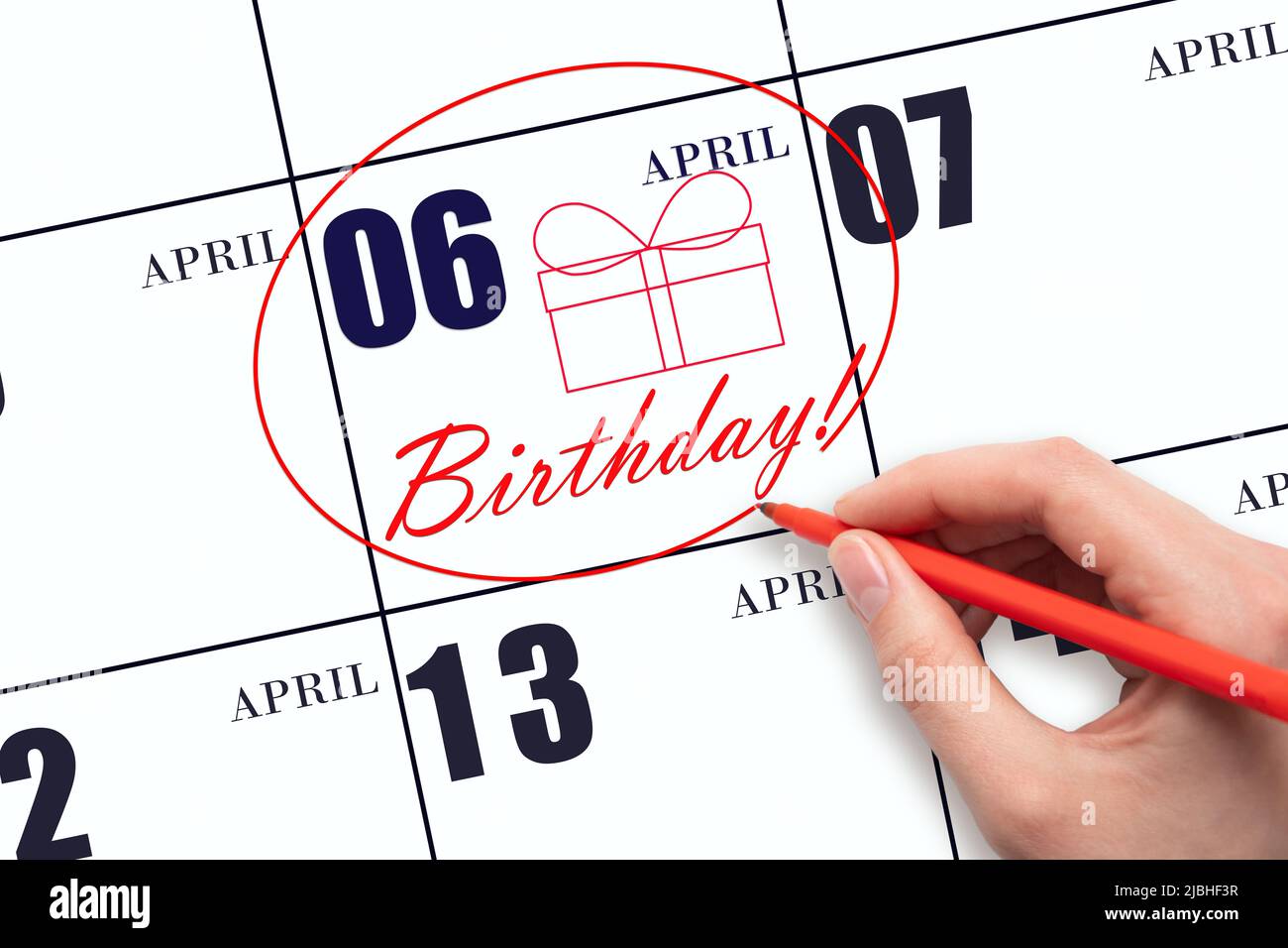 6th day of April.  The hand circles the date on the calendar 6 April, draws a gift box and writes the text Birthday. Holiday. Spring month, day of the Stock Photo