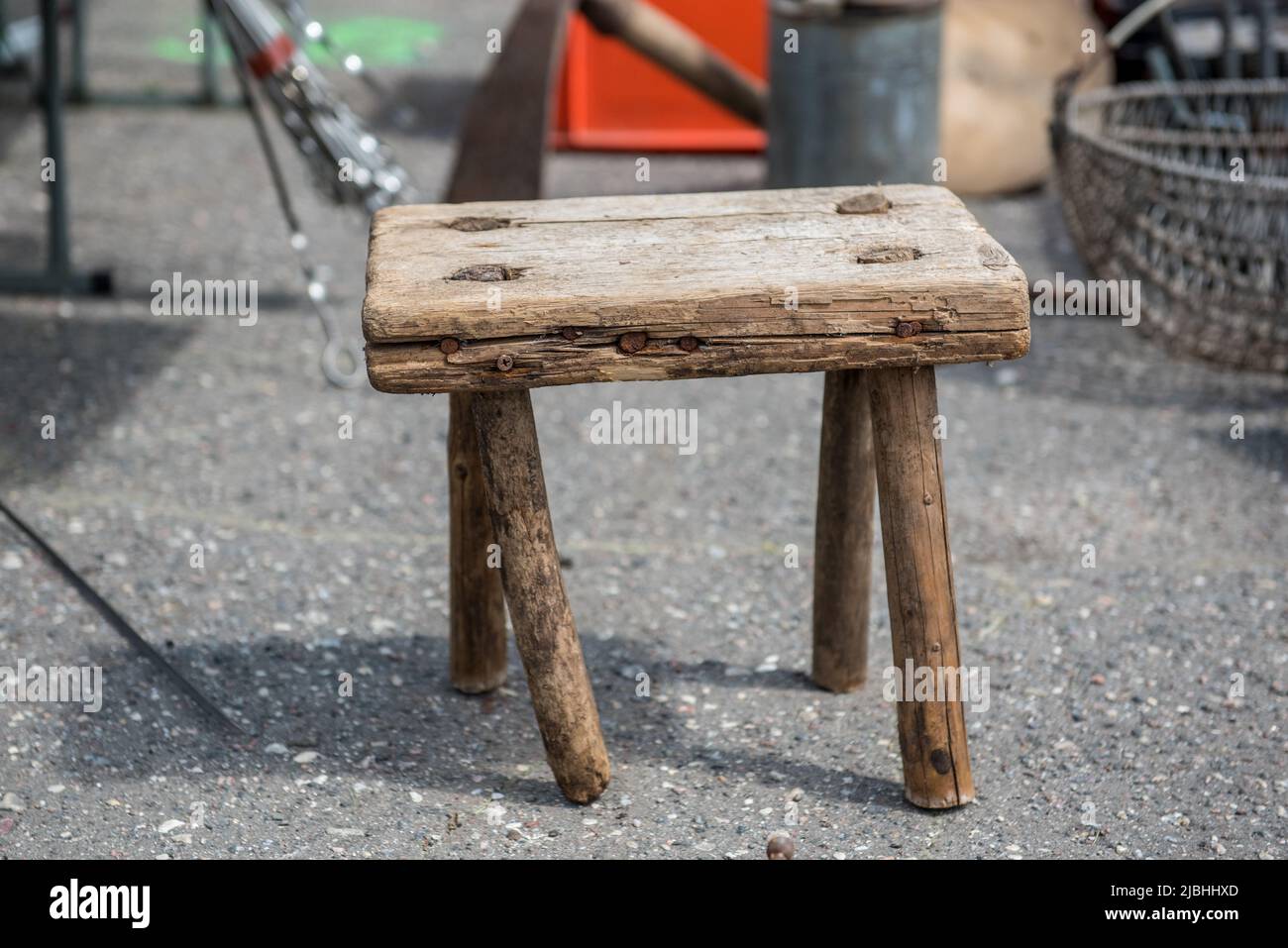 Old antique wooden stool. Old, worn wooden stool. Little stool in a