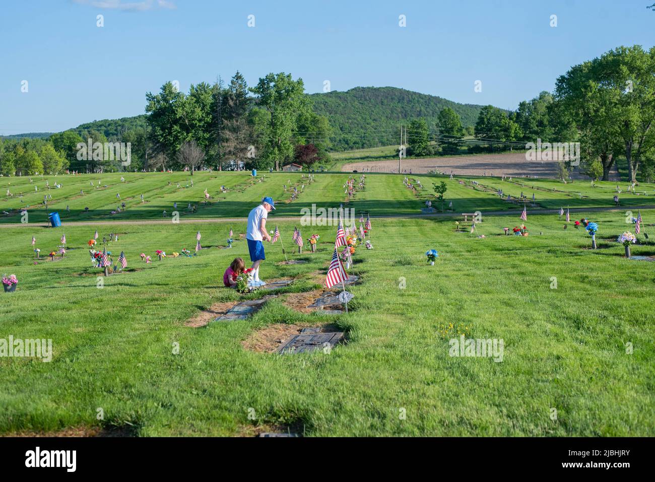 A man tends to a grave at a cemetery in rural Pennsylvania on Memorial Day. Stock Photo