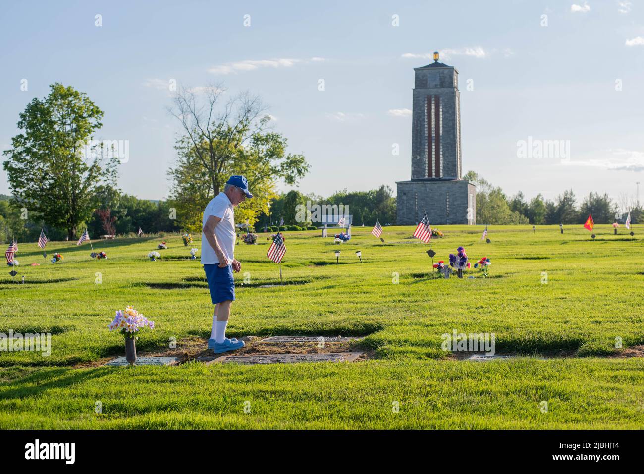A man tends to a grave at a cemetery in rural Pennsylvania on Memorial Day. Stock Photo