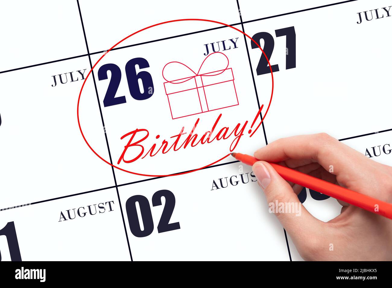 26th day ofJuly. The hand circles the date on the calendar 26July, draws a gift box and writes the text Birthday. Holiday. Summer month, day of the ye Stock Photo