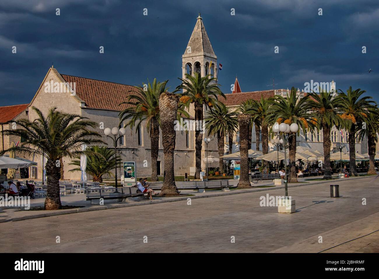 Trogir, Croatia- September 4, 2021: Promenade along the pier of old Venetian town, Trogir, Croatia. A storm is approaching and the clouds are black Stock Photo