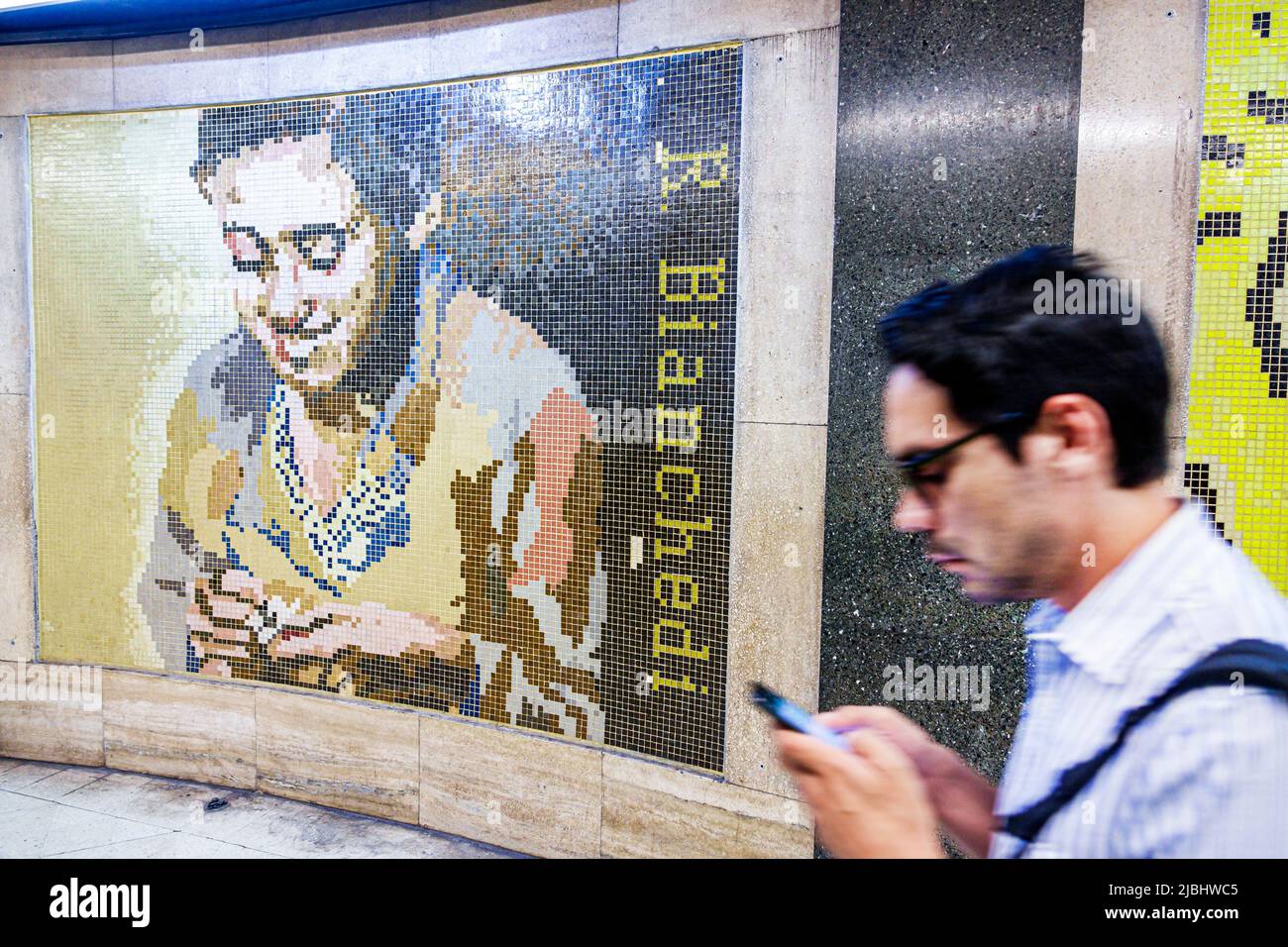 Buenos Aires Argentina,Subte subway Callao,station,tile mural,Remo Bianchedi,man male,checking looking reading texting messaging smartphone Hispanic Stock Photo