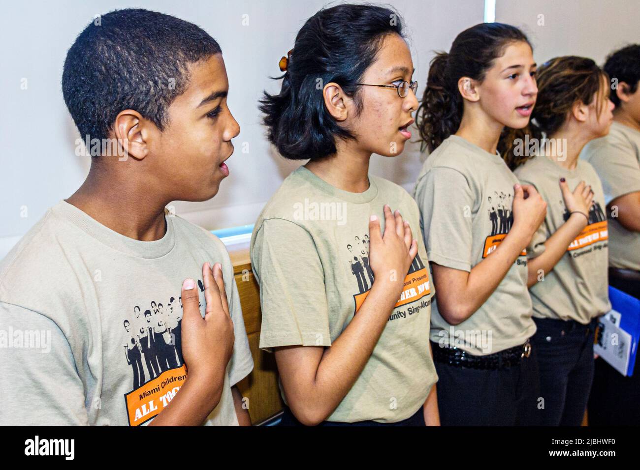 Miami Beach Florida,Public Library,Miami Children's Chorus,group music students hand over heart reciting Pledge of Allegiance,boy girls Hispanic Asian Stock Photo