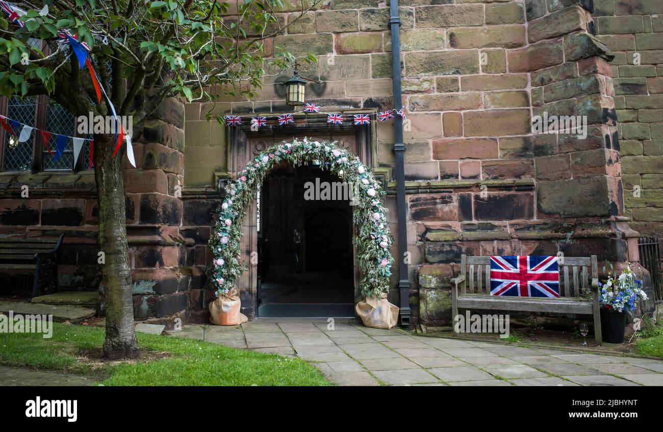 Wedding floral decoration around the doorway of St Mary and All Saints' Church, Great Budworth, Cheshire during the platinum jubilee. Stock Photo