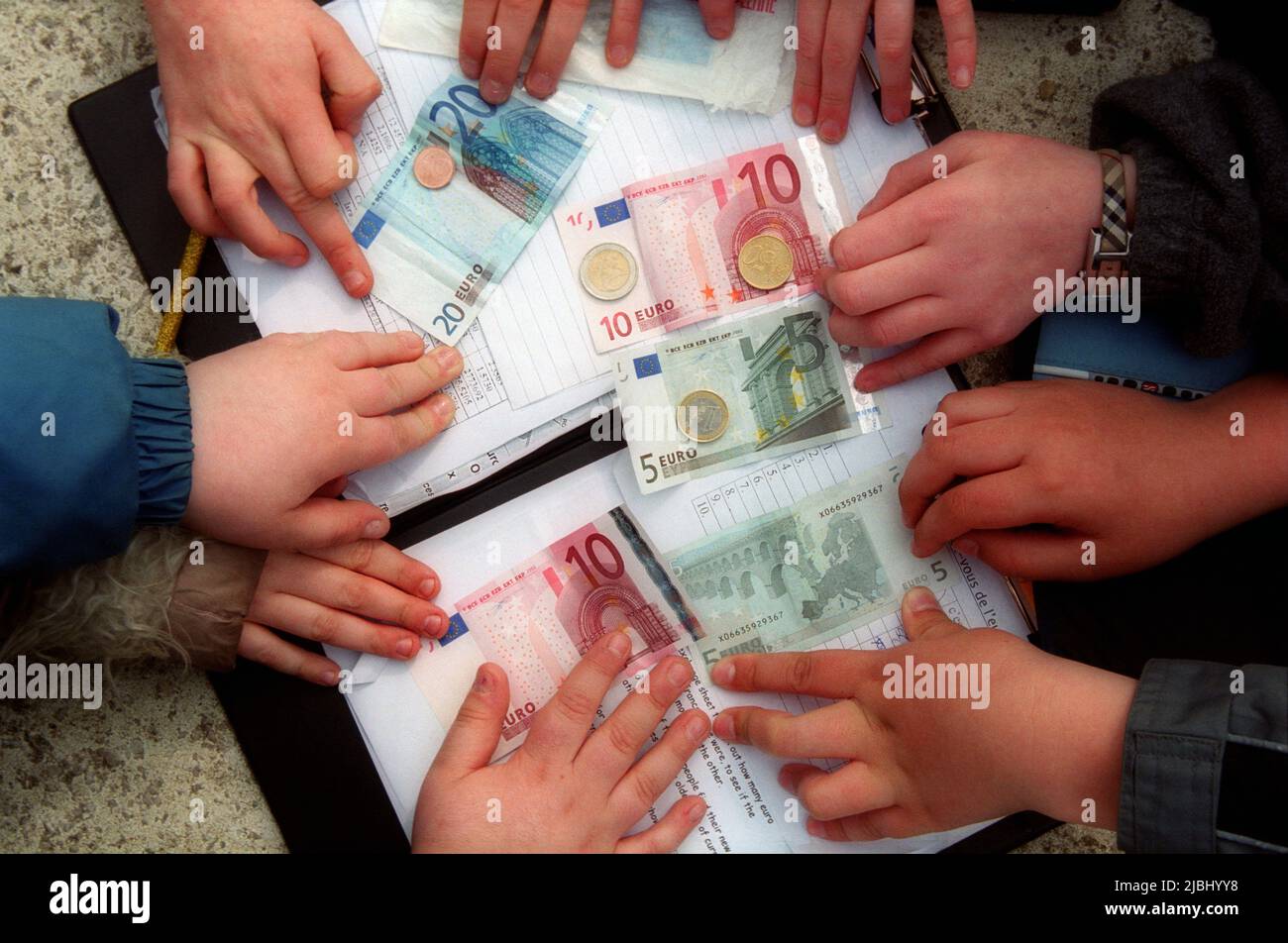 childrens hands playing with Euro notes and bills Stock Photo