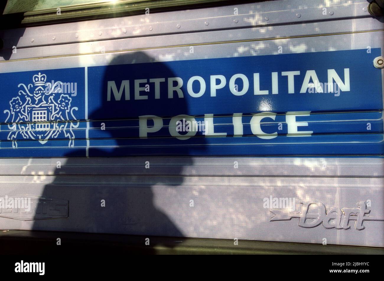 Shadow sillohette of met police officer against Metropolitan police badge Stock Photo