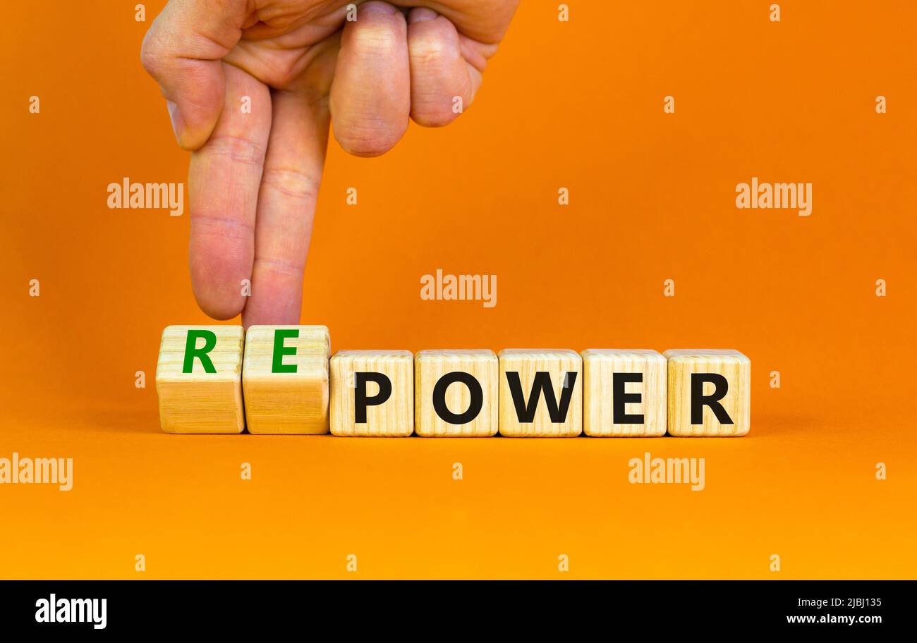 Power or repower symbol. Businessman turns wooden cubes and changes concept words Power to Repower. Beautiful orange table orange background. Business Stock Photo