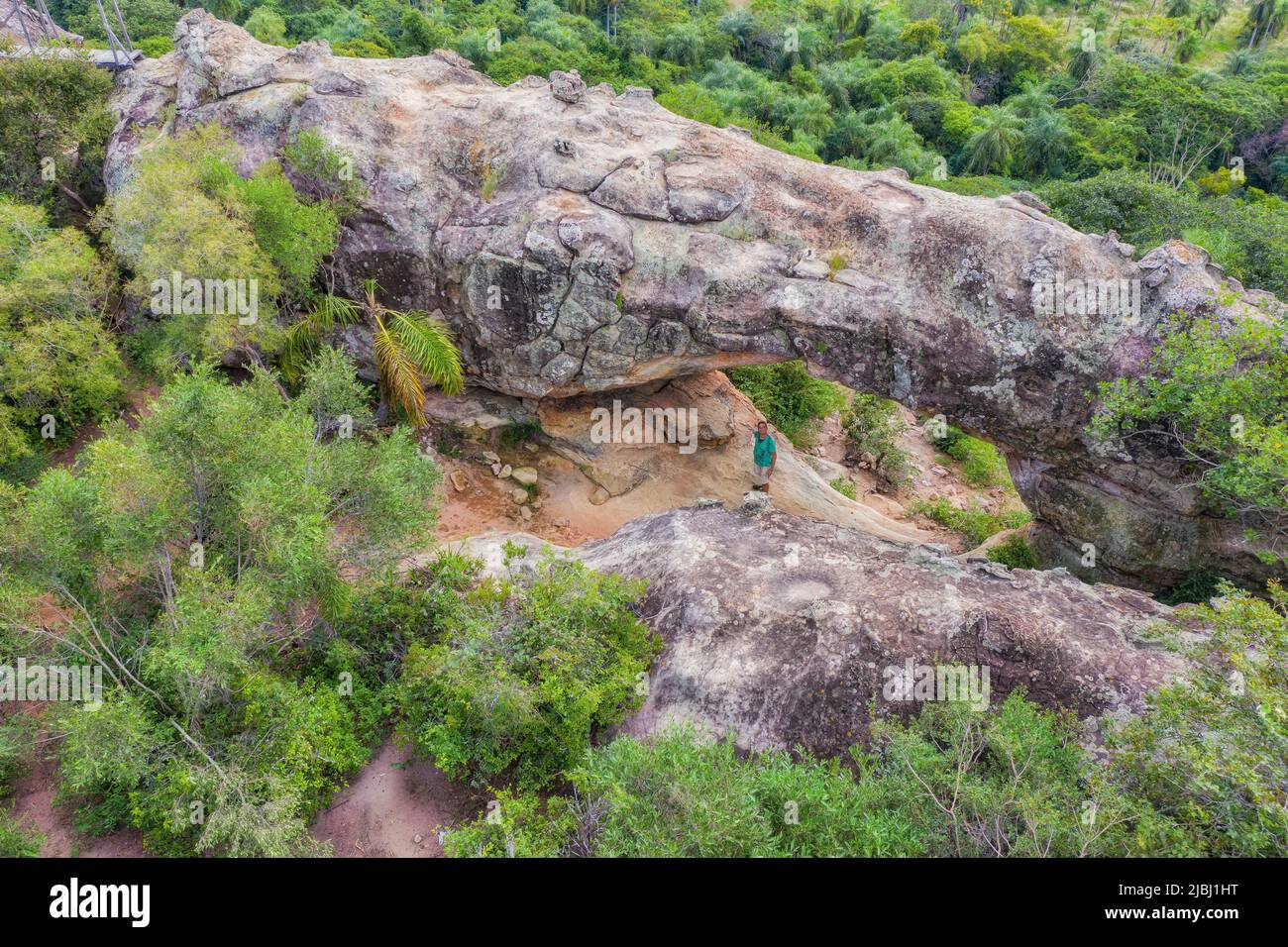 A man under the rock arch on Cerro Arco in Tobati in Paraguay. Stock Photo