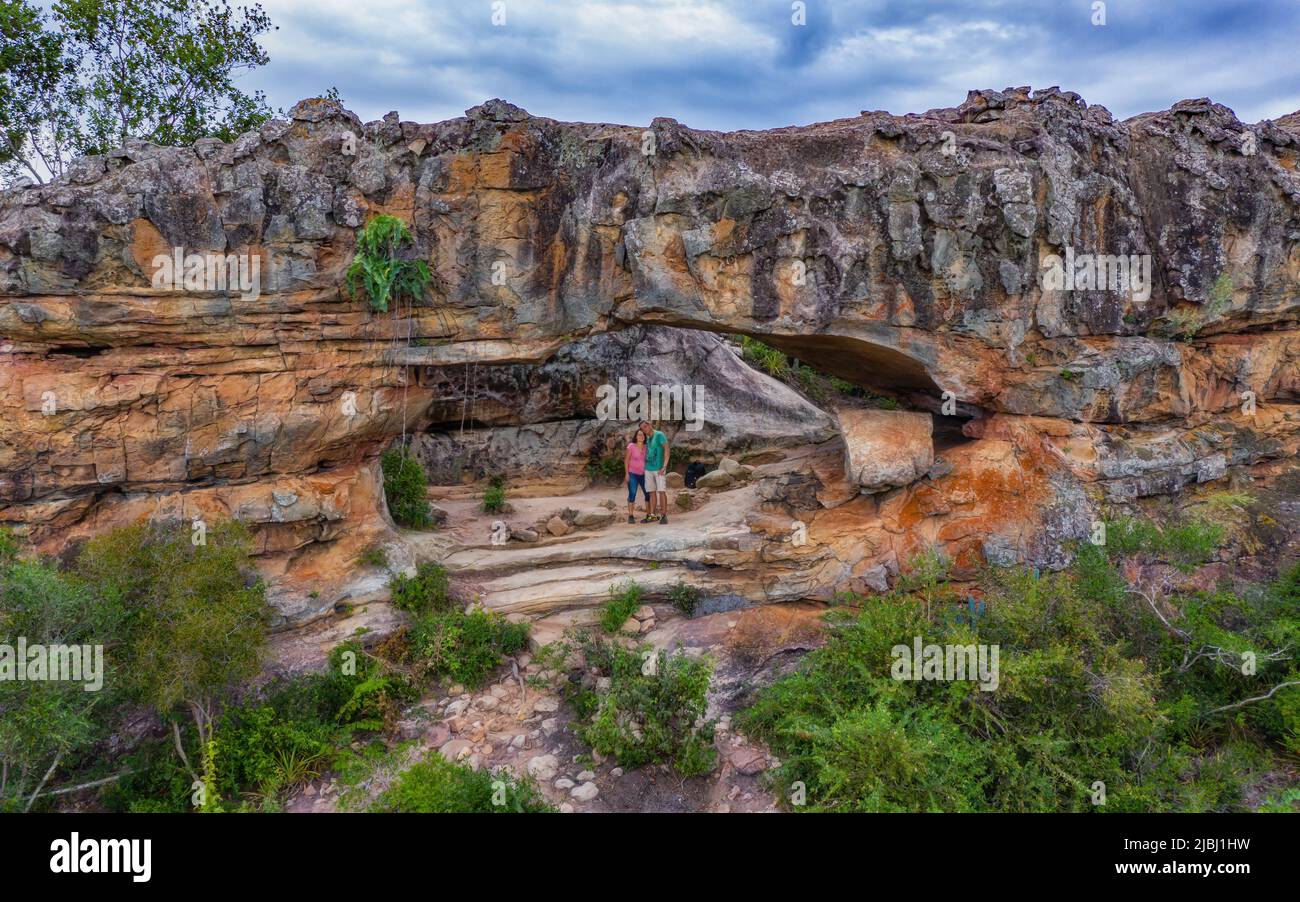 Aerial view of a woman and a man in the rock arch on Cerro Arco in Tobati in Paraguay. Stock Photo