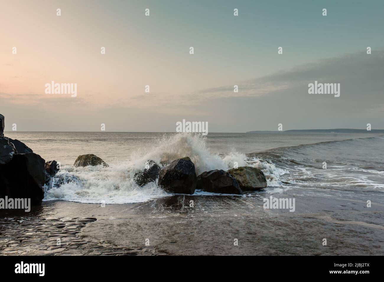 Breaking waves crashing over rocks on the sea shore Stock Photo - Alamy