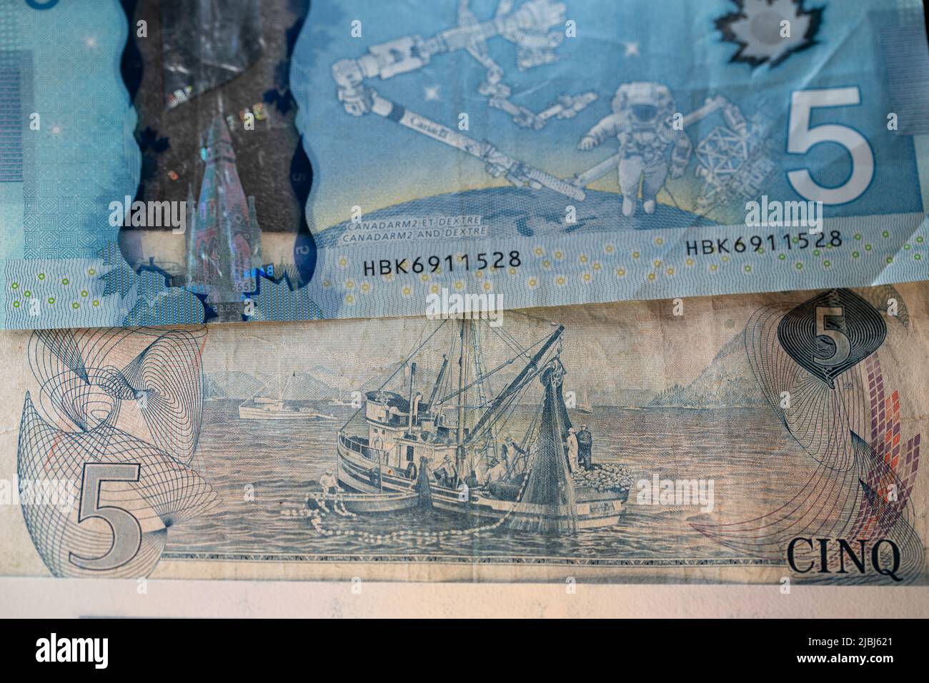 Toronto, Canada - October 30. 2021: Five Canadian Dollar banknotes, old bill with fishing Industry image and new five CAD with astronaut and Space Sta Stock Photo