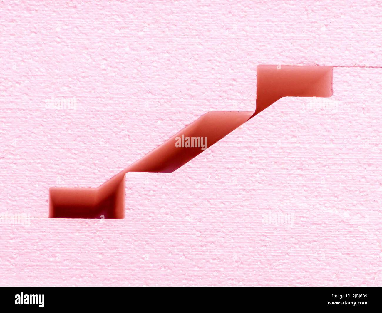 pink blocks of a complex profile lie in stacks - close-up and selective focus of decorative panels Stock Photo