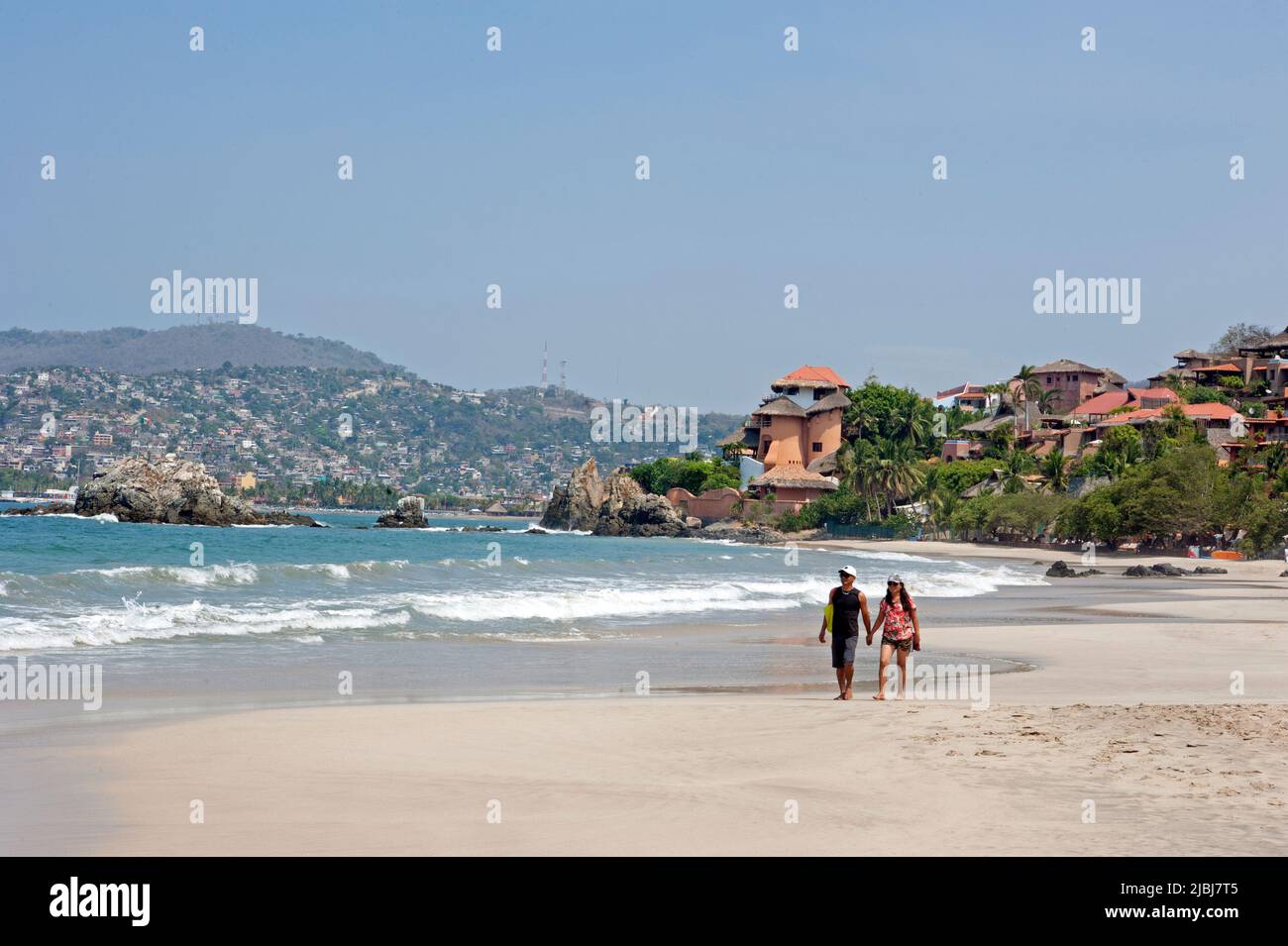 Couple strolling on the Playa La Ropa beach in Zihuatanejo, Mexico Stock Photo