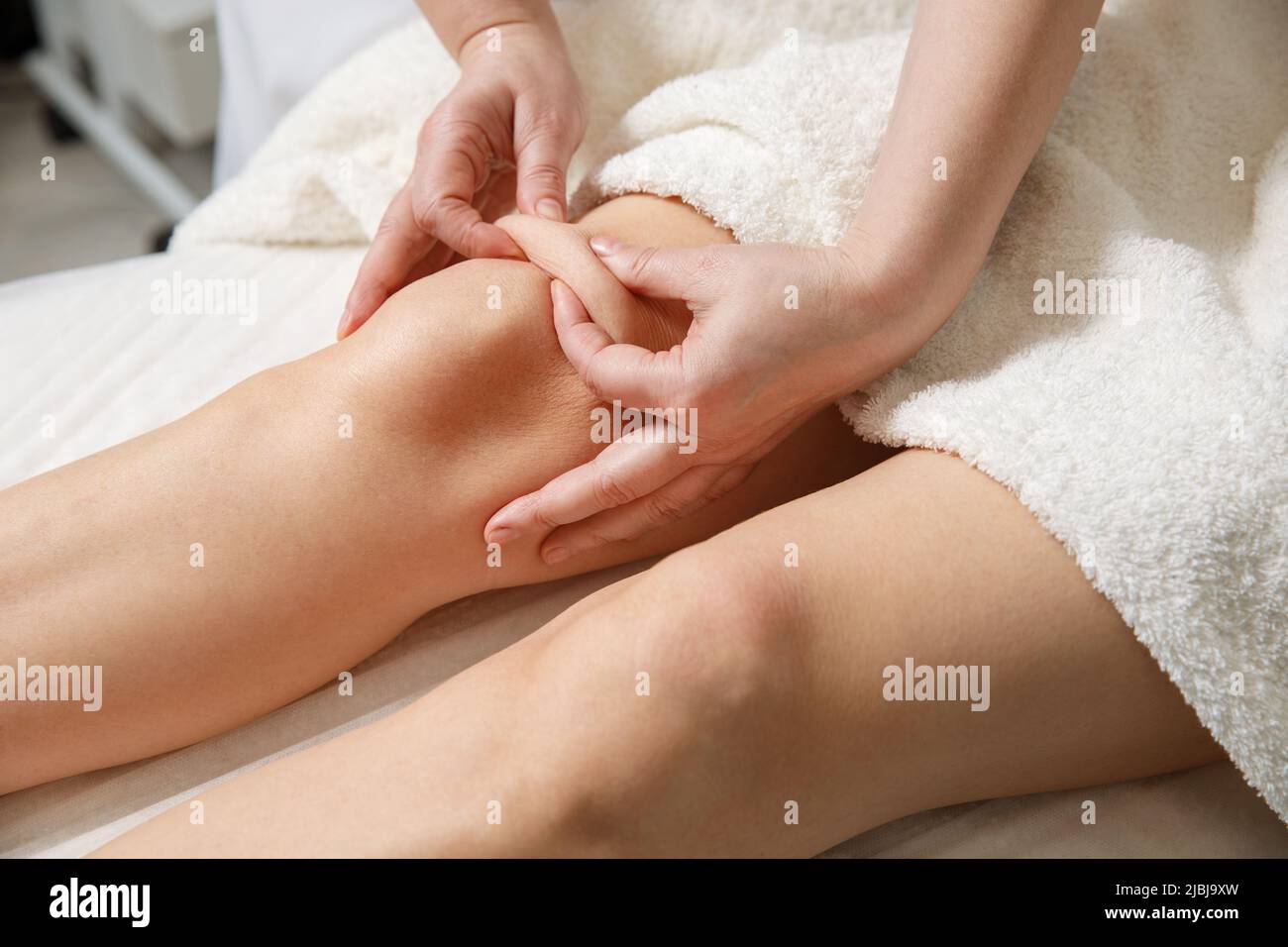 Close up of knee massage procedure in spa salon. Stock Photo