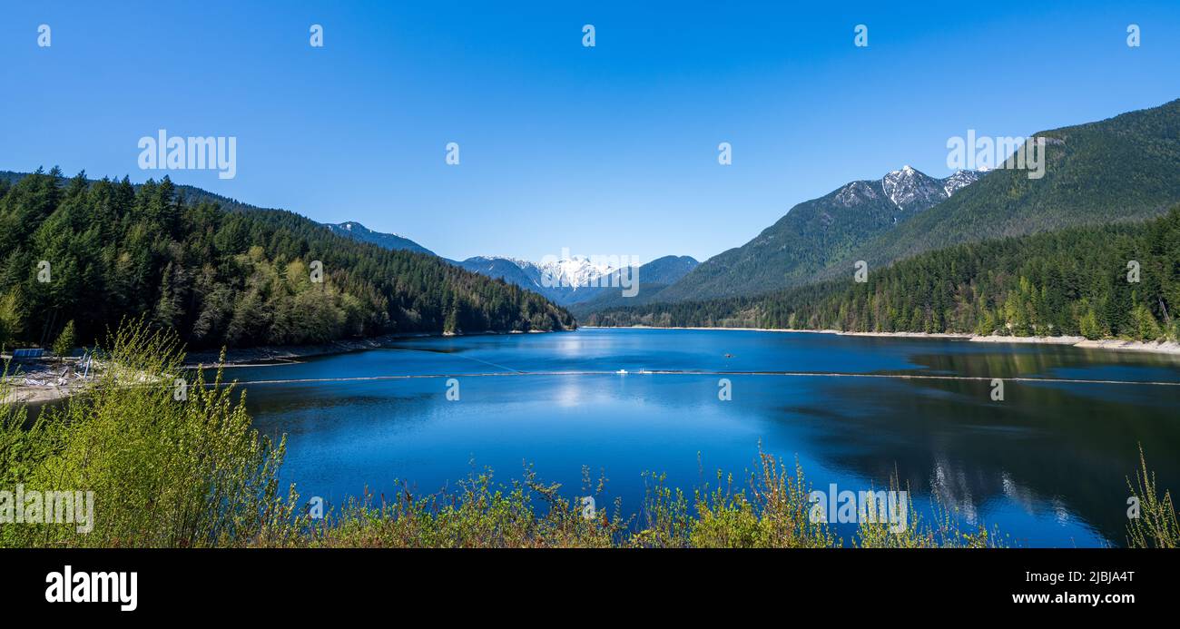 Capilano Lake reservoir Capilano watershed in springtime sunny day. Panoramic view. North Vancouver, BC, Canada. Stock Photo