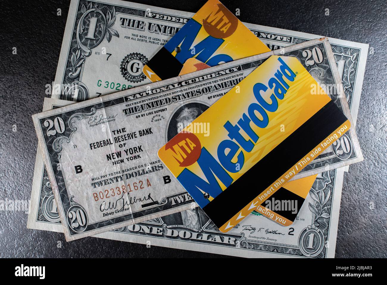 NYC Metro card on top of old twenty Dollar Bill from the Federal Reserve Bank of New York. MTA transit Ticket for Subway on cash and Banknotes Stock Photo