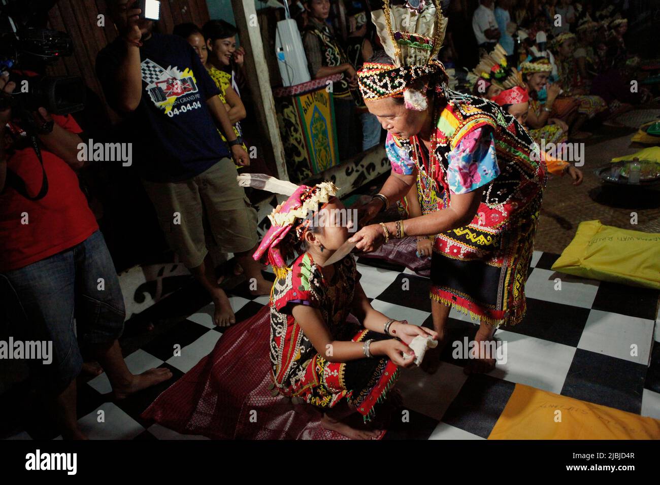 A senior woman conducting a ritual with a child, a part of a welcome ...