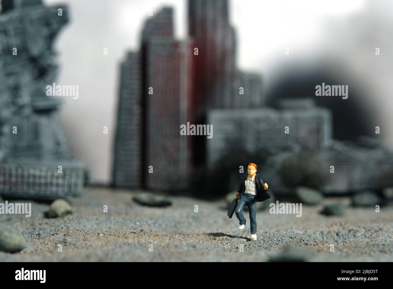 Miniature people toy figure photography. School education for students in conflict areas concept. Young men pupil running on ruined city diorama backg Stock Photo