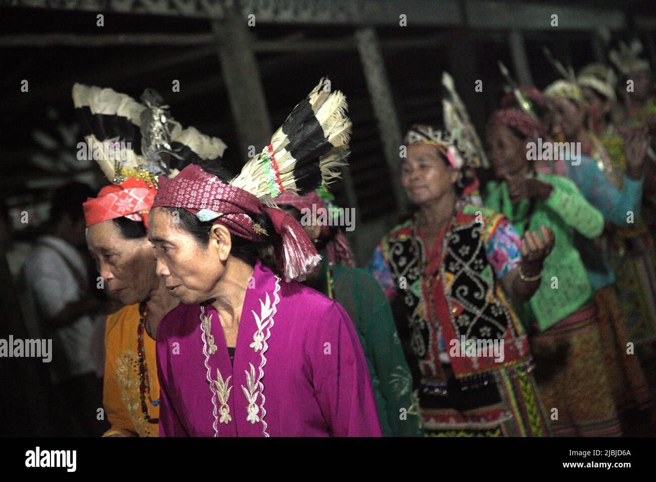 Women dancing in a line as they are welcoming guests during an ecotourism event at Bali Gundi longhouse of traditional Dayak Taman community in Sibau Hulu, Putussibau Utara, Kapuas Hulu, West Kalimantan, Indonesia. Stock Photo