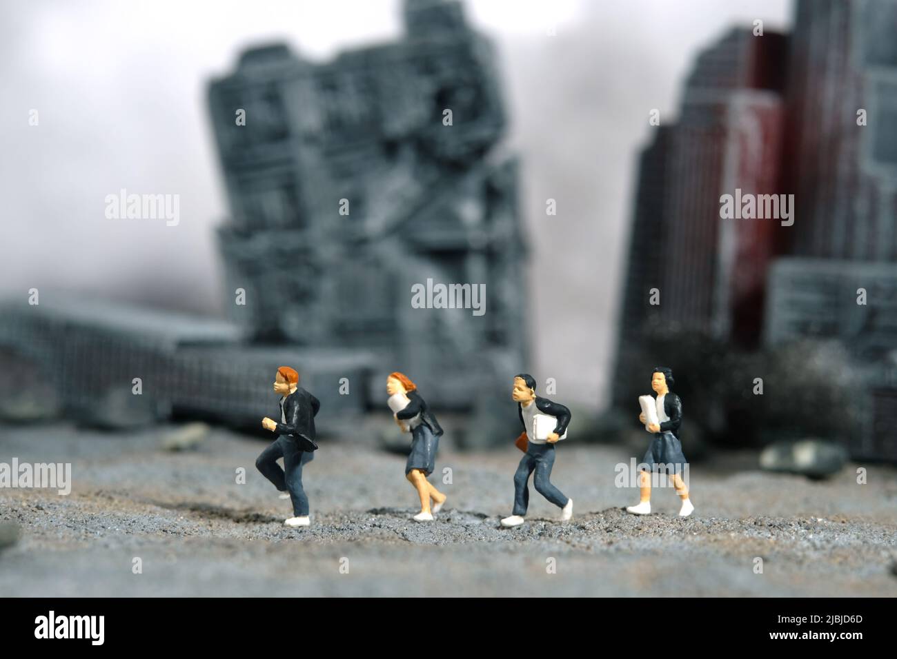 Miniature people toy figure photography. School education for students in conflict areas concept. Pupils running on ruined demolished city diorama bac Stock Photo