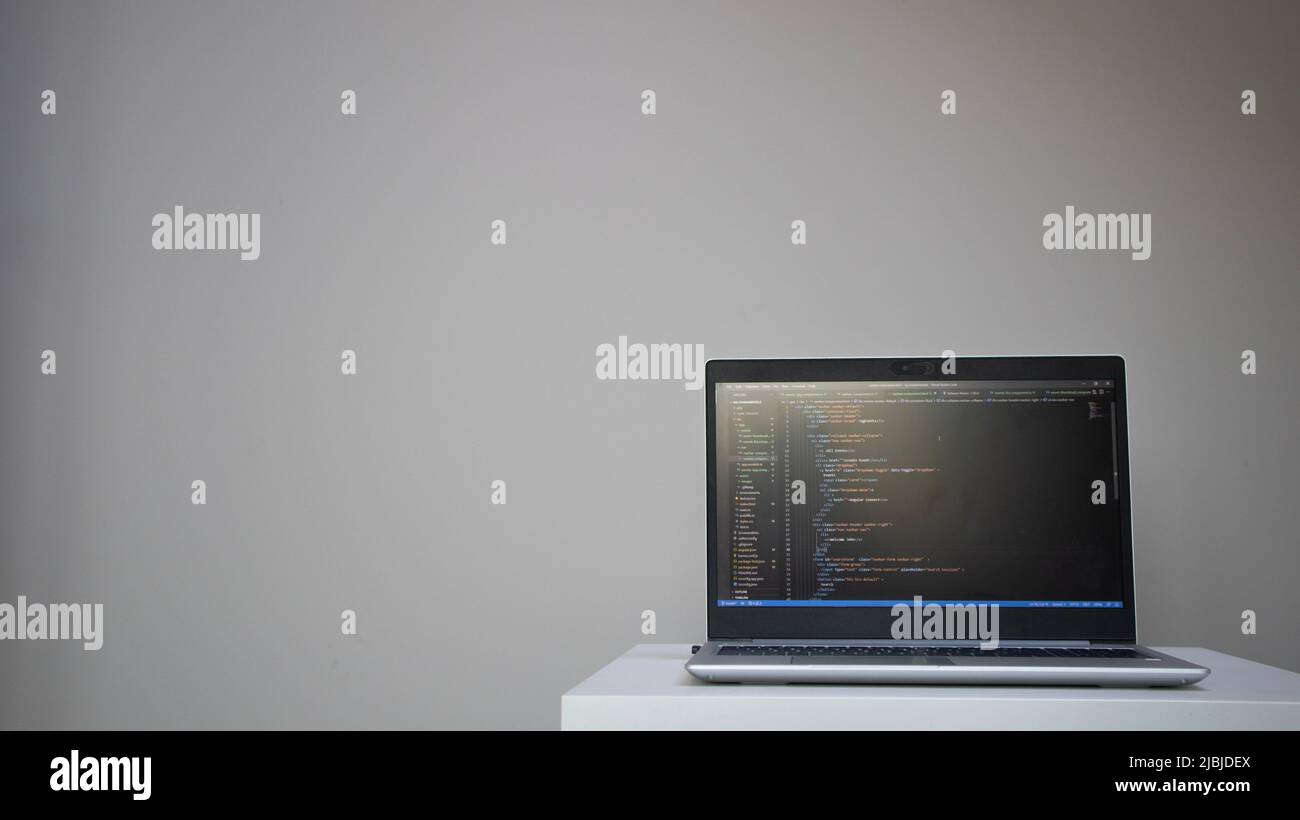 Opened laptop with code on the screen on the table Stock Photo