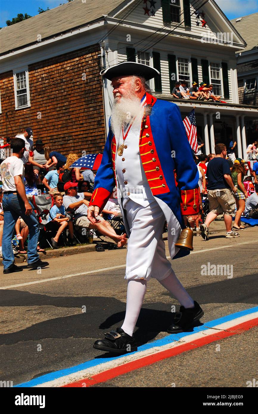 An elderly man dressed as a Colonial American soldier marches in the