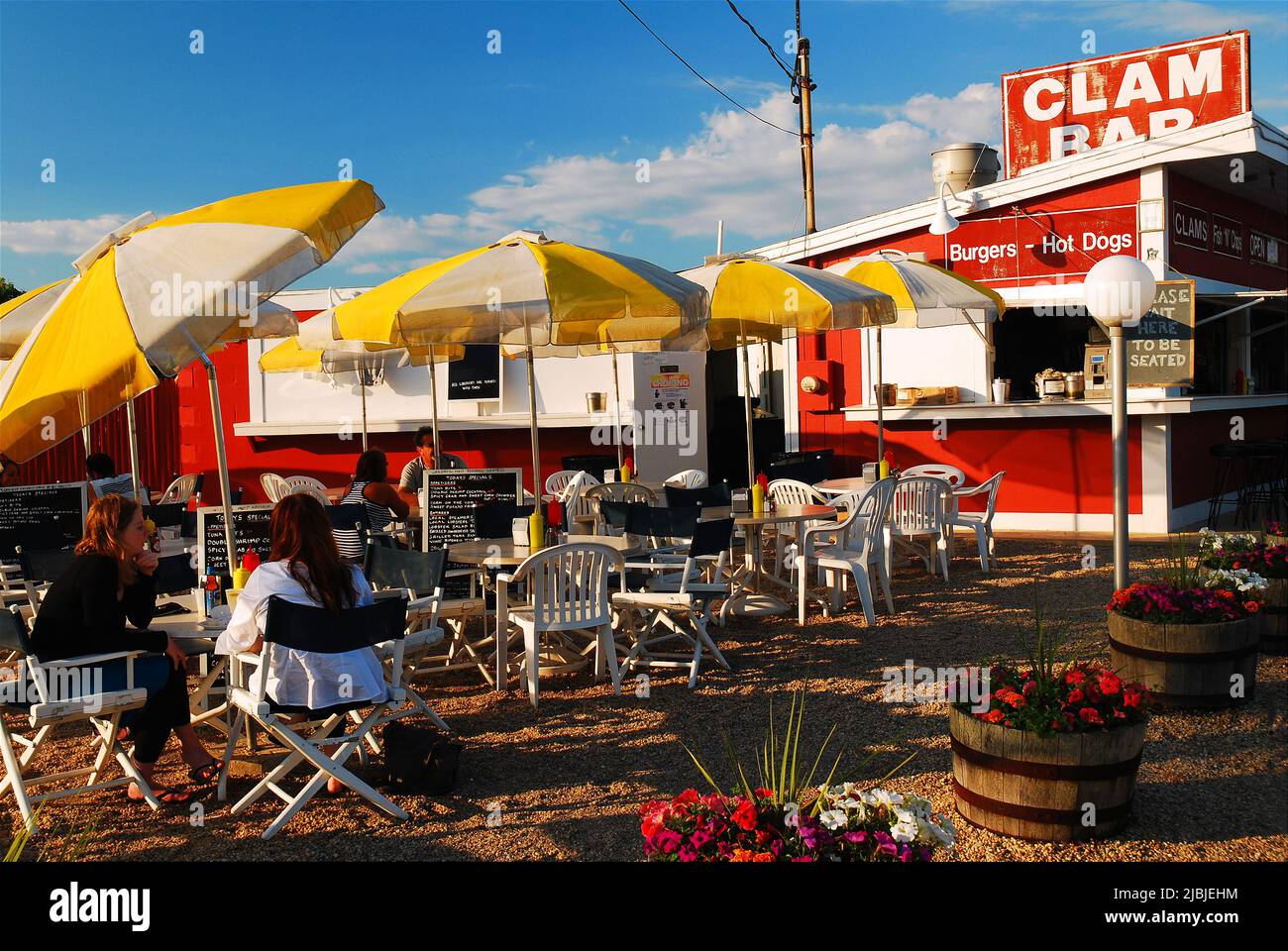 Folks enjoy a sunny summer day eating al fresco at a clam bar in The Hamptons on Long Island Stock Photo