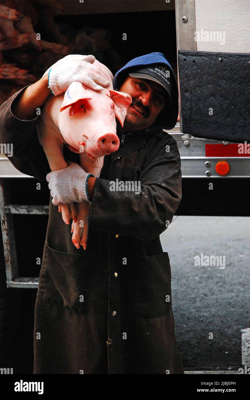 A delivery man carries a full pig to a full pig to a restaurant in Chinatown in San Francisco Stock Photo