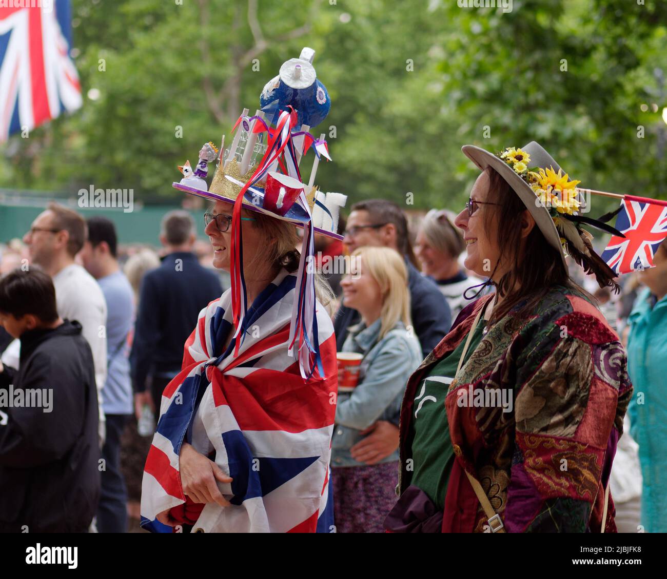 London, Greater London, England, June 04 2022: Jubilee Concert at The Mall. Lady draped in a union jack flag wears a teapot themed hat. Stock Photo