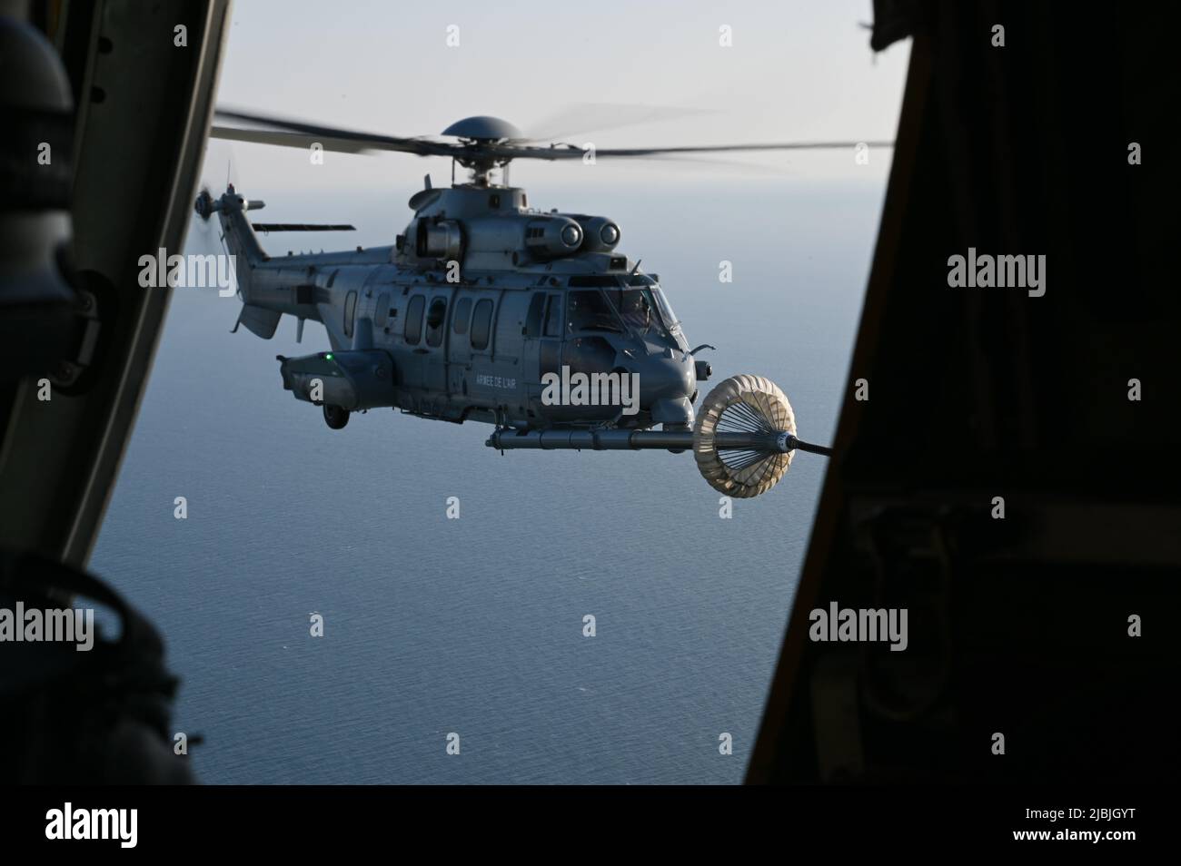 A U.S. Air Force MC-130J Commando II assigned to the 352d Special Operations Wing performs a helicopter air-to-air refueling with an Armée de l'Air et de l’Espace (French Air and Space Force) EC725 Caracal on May 5, 2022. Both aircraft supported exercise Athena, a French-led joint and combined Special Operation Forces exercise that validates the full spectrum of integrated component and partner capabilities. Training with joint and combined Allies increases lethality and enhances interoperability, allowing our forces to counter military aggression and coercion by sharing responsibilities for c Stock Photo