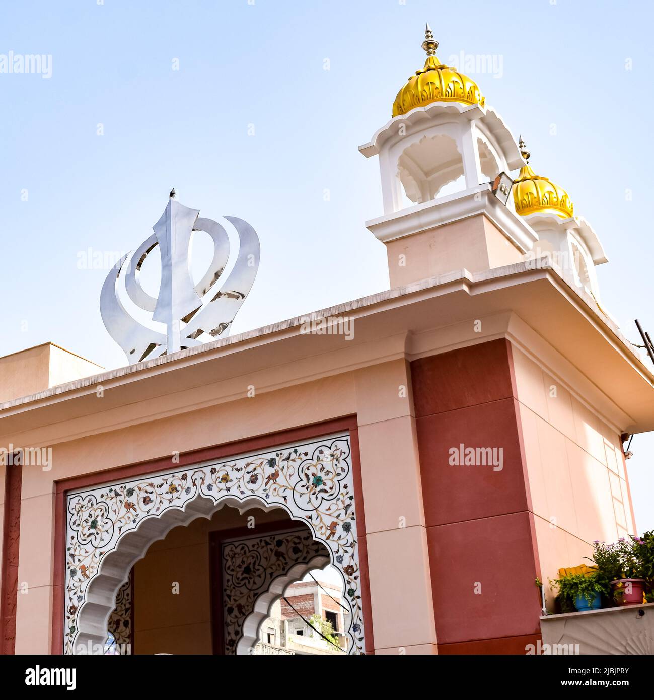 Khanda Sikh holy religious symbol at gurudwara entrance with bright blue sky image is taken at Sis Ganj Sahib Gurudwara in Chandni Chowk opposite Red Stock Photo