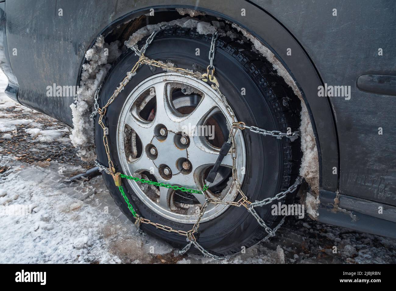 Close-up of snow chains on a car wheel in winter. The concept of safety on snowy roads Stock Photo