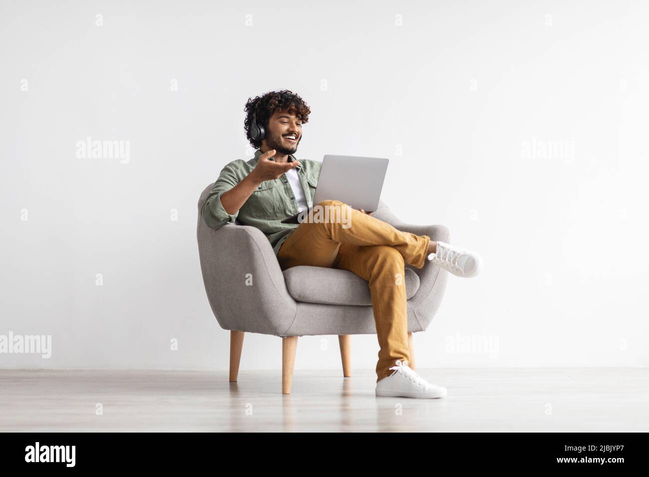 Positive handsome indian having video conference, using notebook Stock Photo