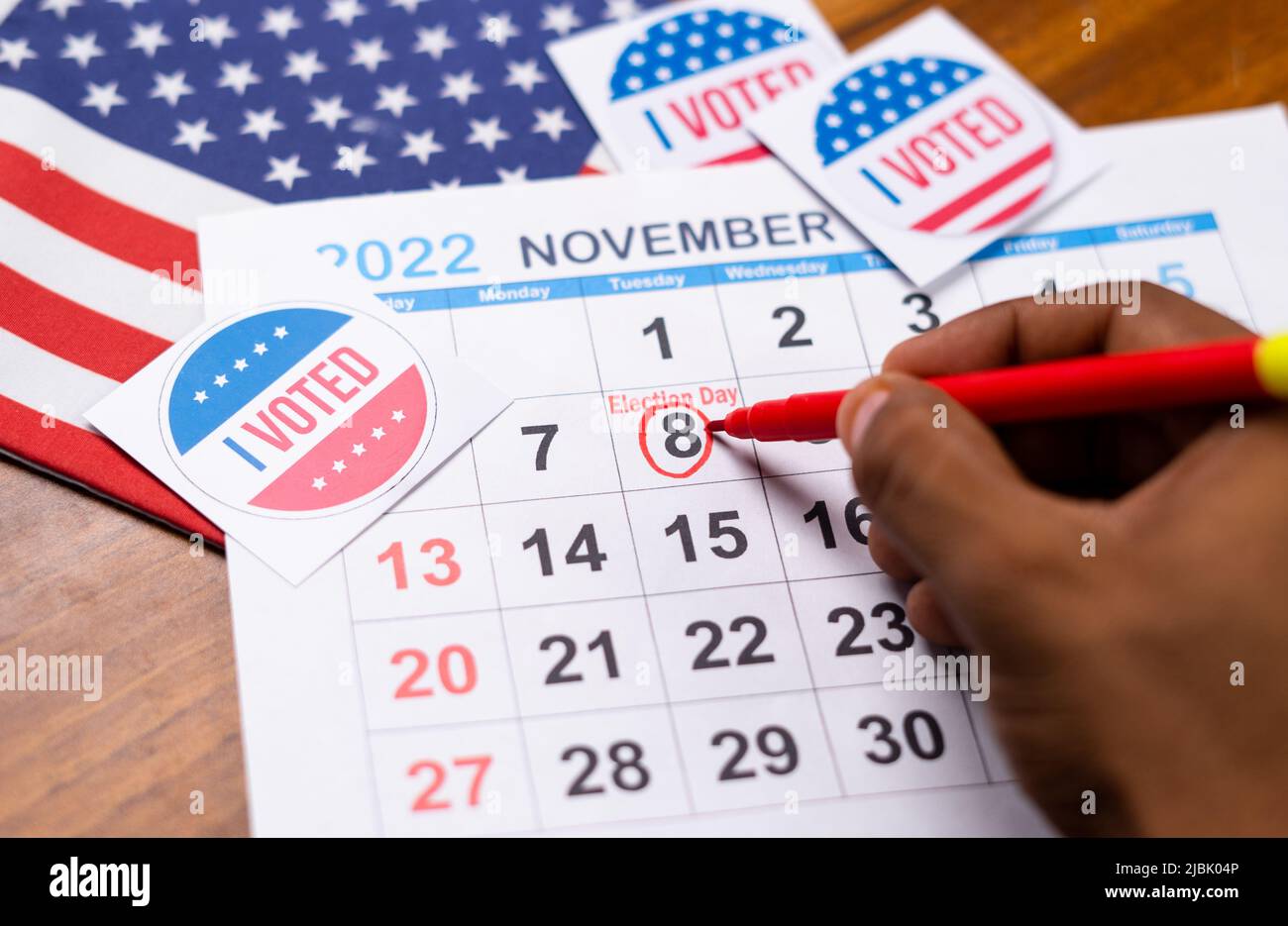 close up shot of hands marking November 8 as reminder for polling in 2022 US or american mediterm election. Stock Photo