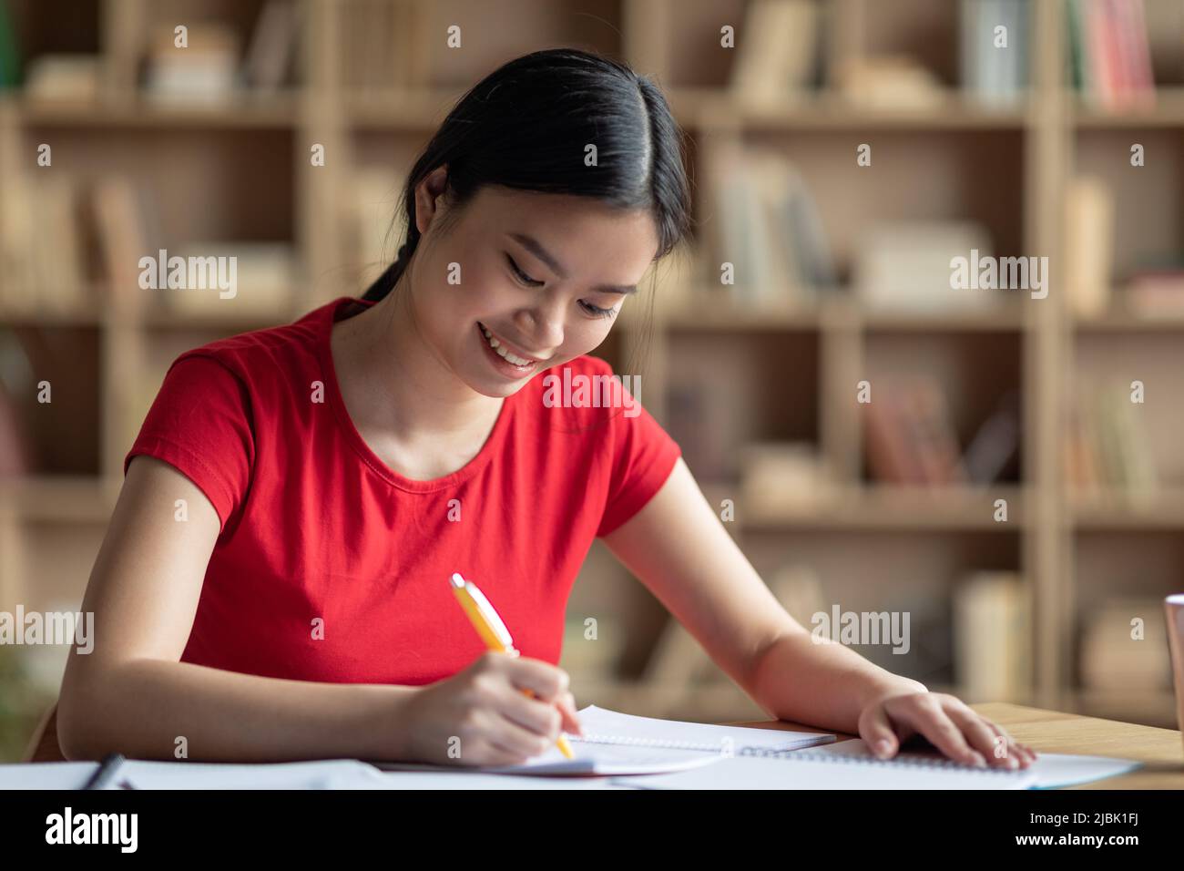 Glad pretty busy smart japanese female make notes at table, prepare for